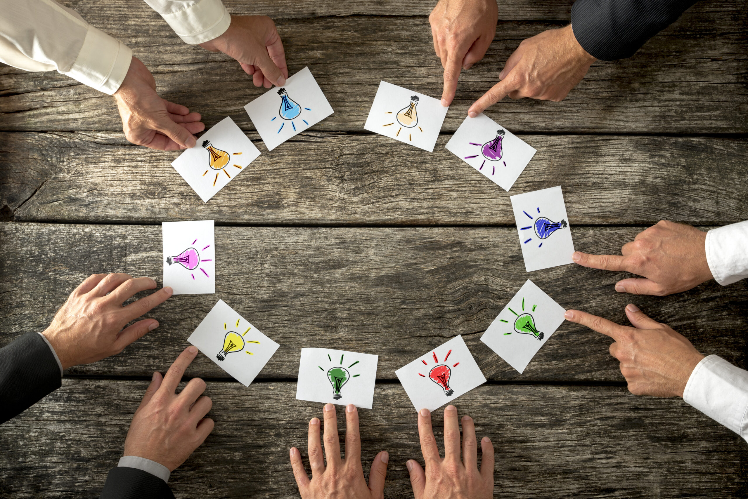 Teamwork,And,Brainstorming,Concept,With,Businessmen,Seated,Around,A,Table
